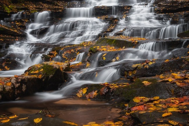 a large waterfall over some water